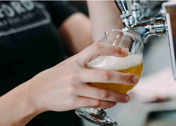 a person pouring a beer into a glass.