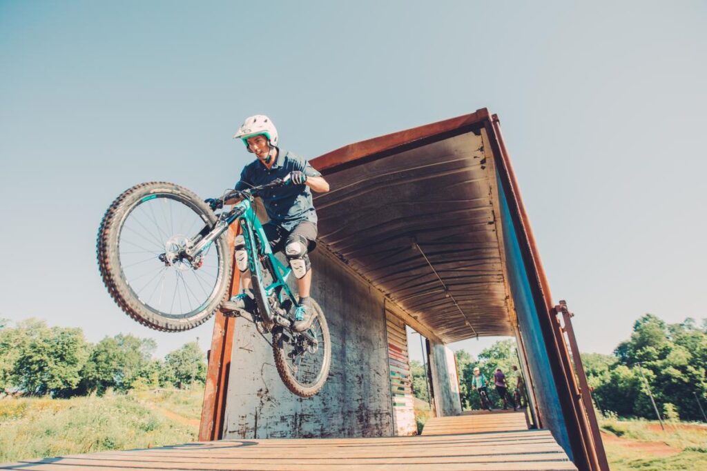 a man riding a mountain bike over a bridge.