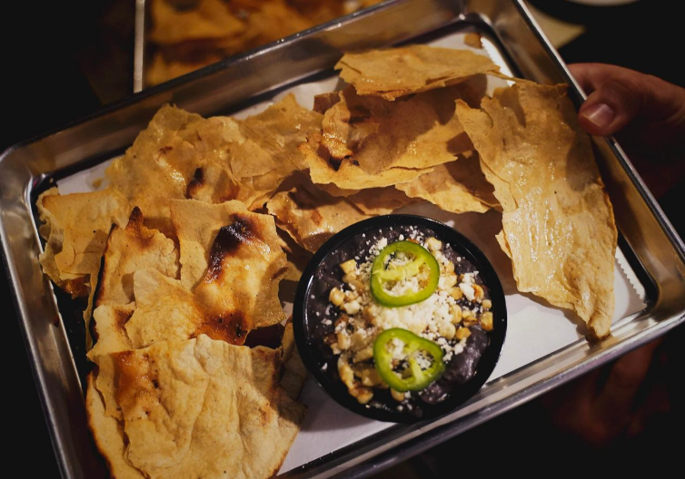 a tray of nachos from Local entrepreneur collaborates with local artist to bring artisanal food, beverages, and art to Downtown Rogers at Yeyo’s Mezcaleria y Taqueria.