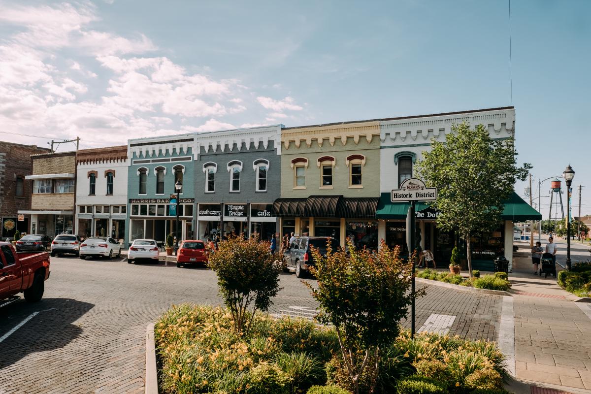 a row of buildings on a street in a small town during spring.