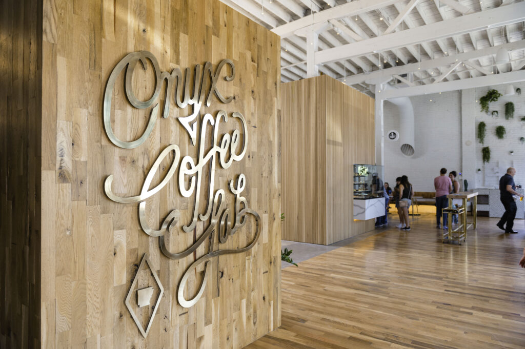 an office with a wooden wall and a sign that says one coffee.