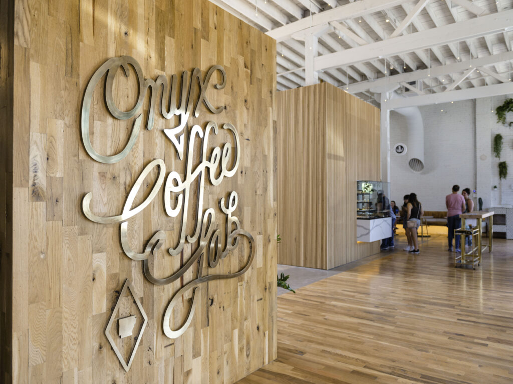 an office with a wooden wall and a sign that says one coffee.