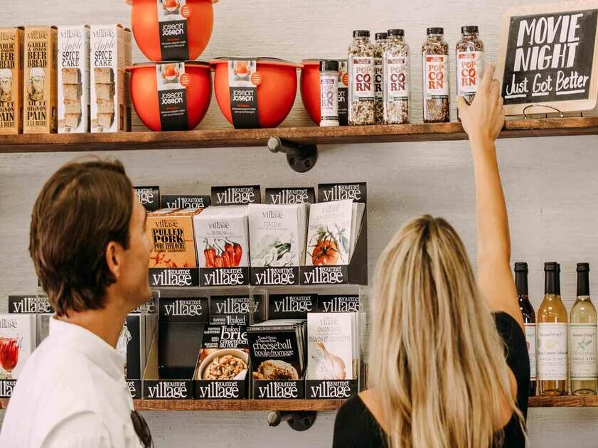 a man and woman looking at shelves in a store.